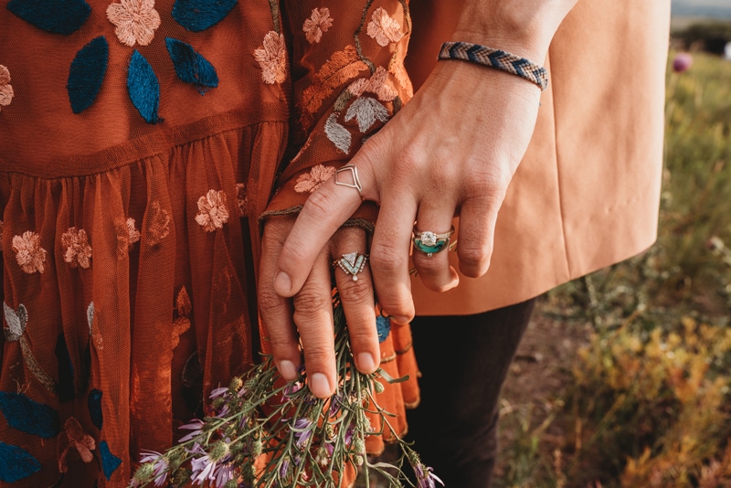 Elopement and Wedding Photography, a couple holds hands outdoors, both women their engagement rings on show on their ring fingers